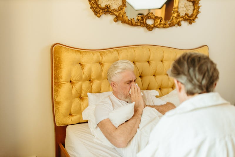 a man blowing his nose in a tissue