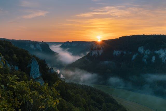 a sun setting over a valley