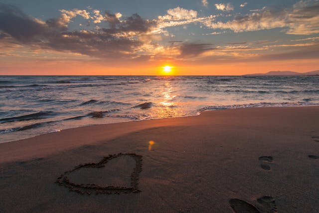 a heart drawn in the sand on a beach