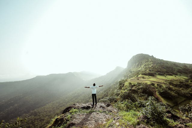 An individual standing on top of a mountain