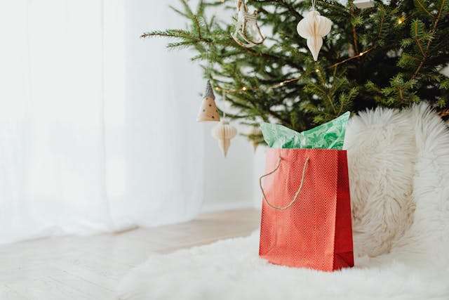 Red gift bag under Christmas tree
