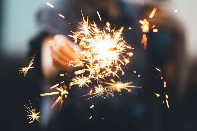Person holding a sparkler at night