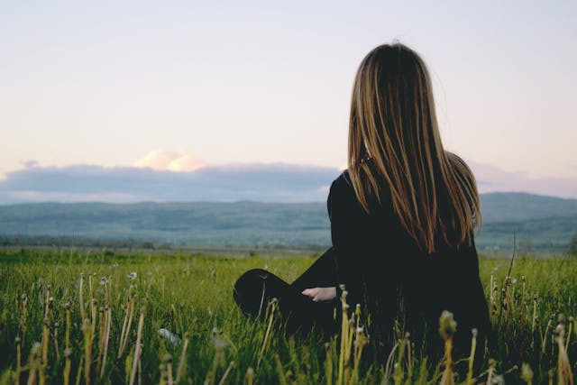 Person sitting in grassy field