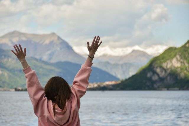 Person celebrating by the lake