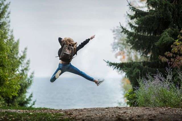 Person jumping near a lake
