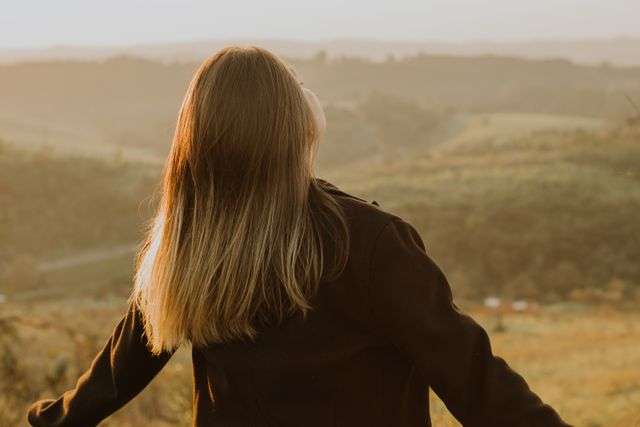 Person enjoying a sunset landscape.