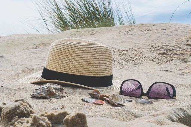 Hat and sunglasses on sandy beach