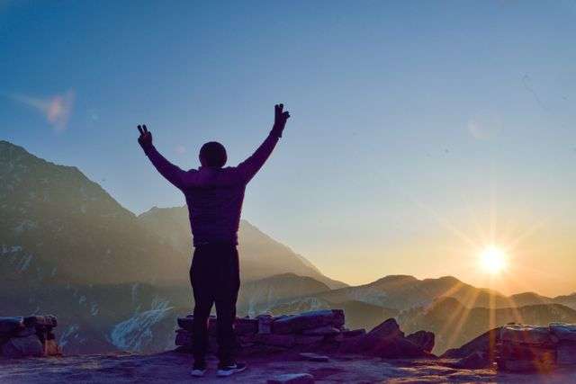 Person celebrating at sunrise mountain