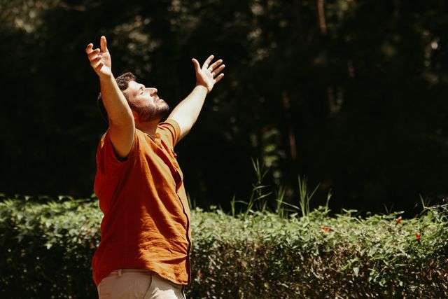 Man with arms raised outdoors