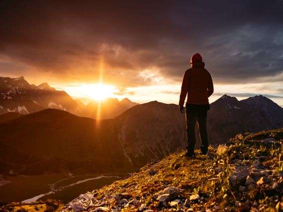 Person overlooking mountains at sunset